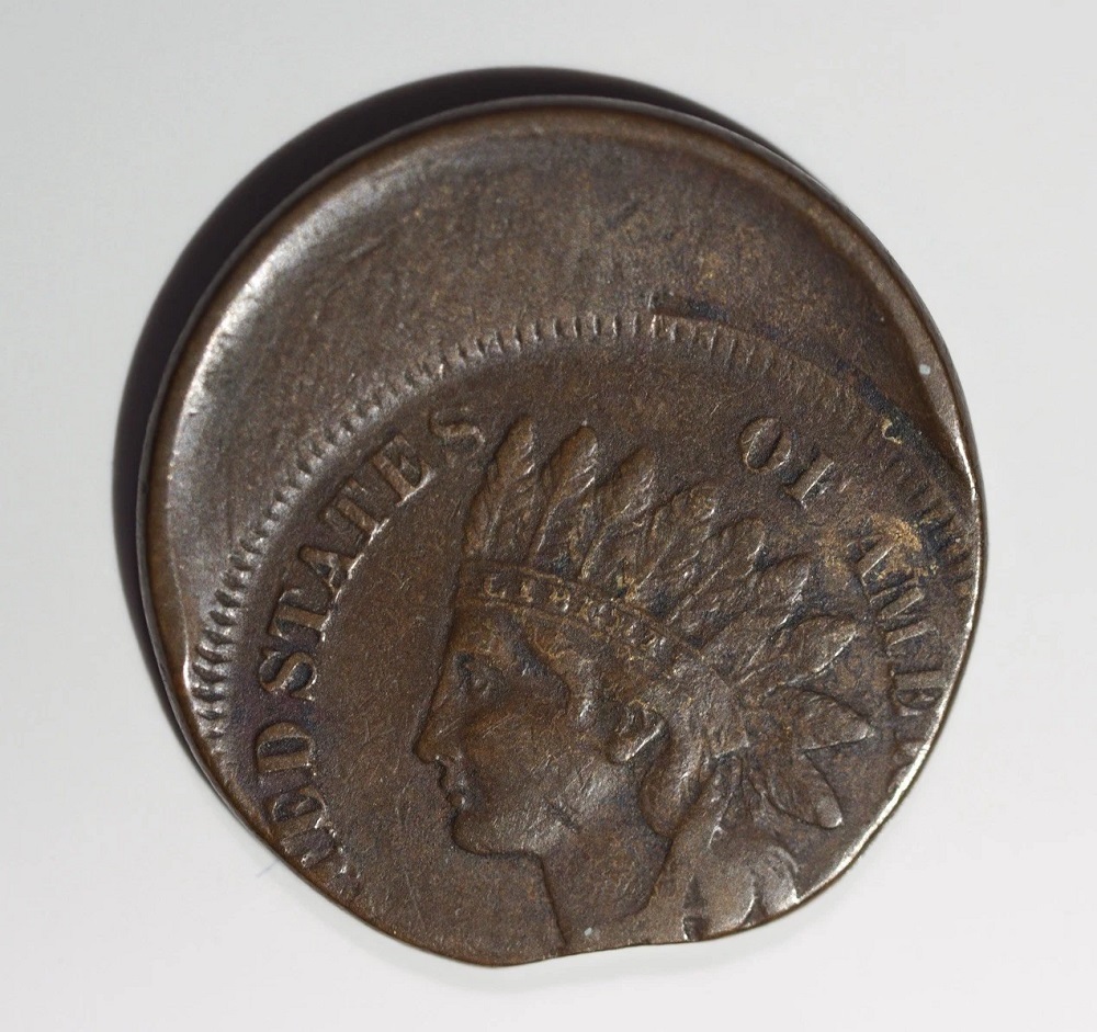 1859 Indian Head cent with off-center strike error showing the design shifted off-center with a blank crescent and the date still visible